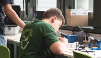 Zu sehen ist ein Junge, der gerade an seinem Bausatz arbeitet.