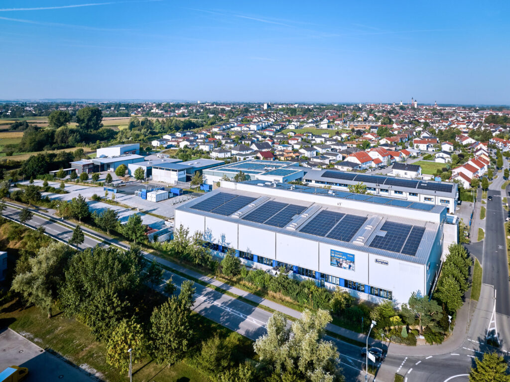 Auf dem Foto sieht man das Werk 1 und Werk 2 der Sonplas GmbH in Straubing. Die Dächer der beiden Gebäude sind flächendeckend mit PV-Anlagen ausgestattet.