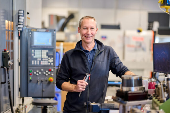 Sonplas Mitarbeiter steht in der Fertigung und schaut in die Kamera