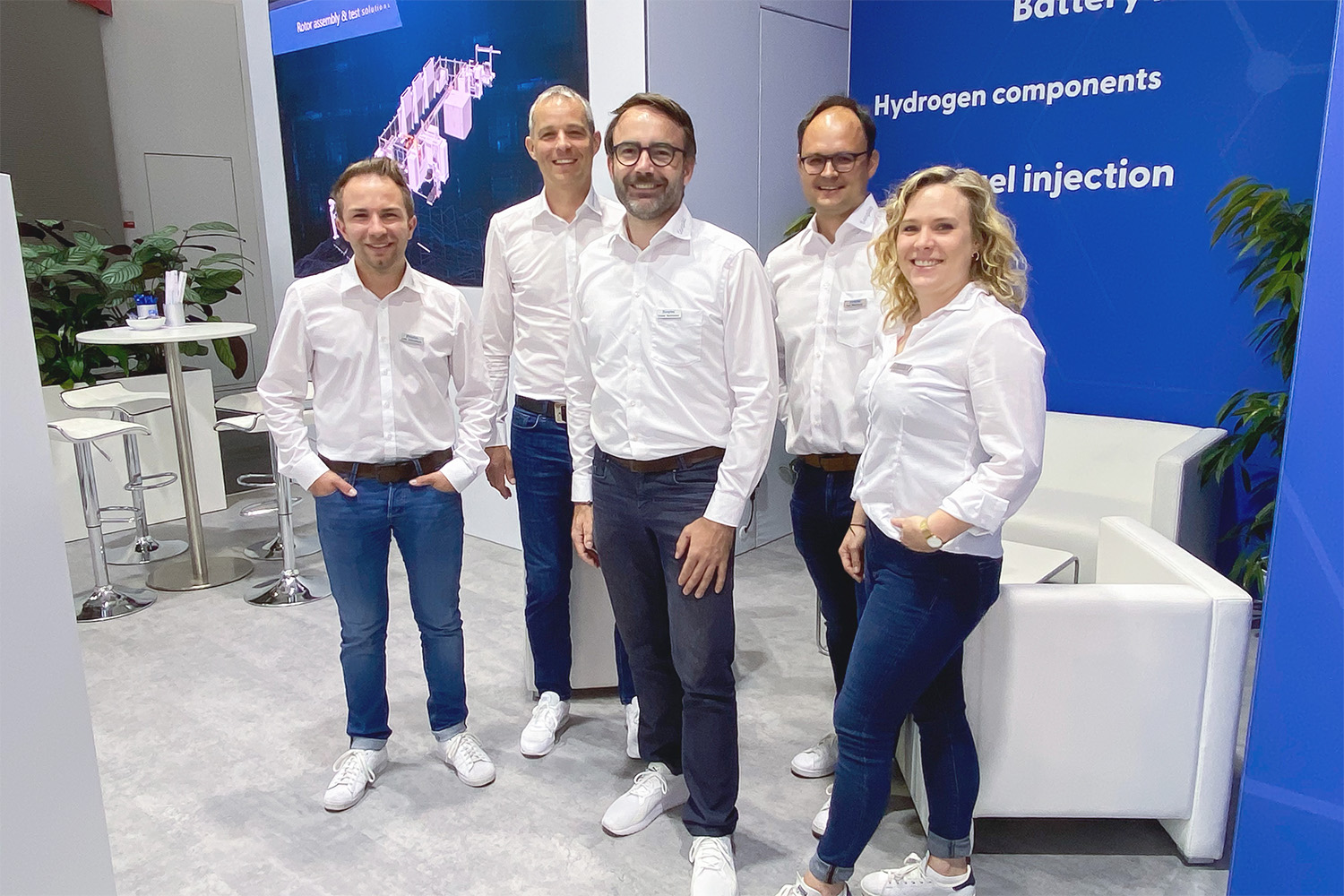 Gruppenbild von vier Mitarbeitenden und einer Mitarbeiterin auf dem Sonplas Messestand.