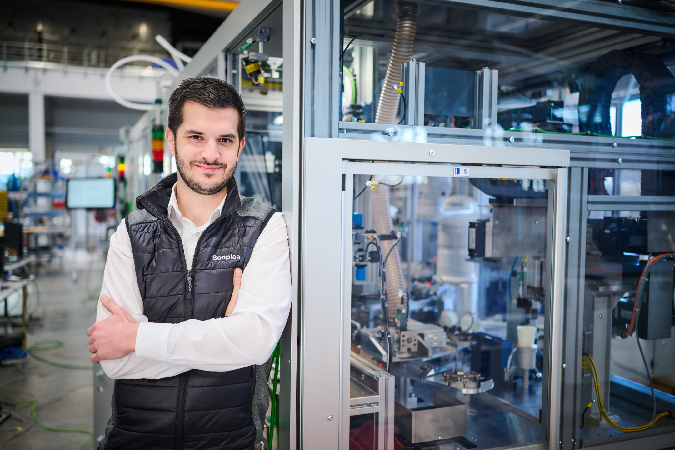 Sonplas Mitarbeiter lehnt an einer Anlage und schaut in die Kamera