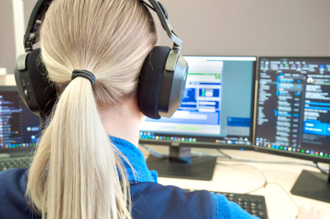 Sonplas Mitarbeiterin mit Headset schaut auf ihre Bildschirme