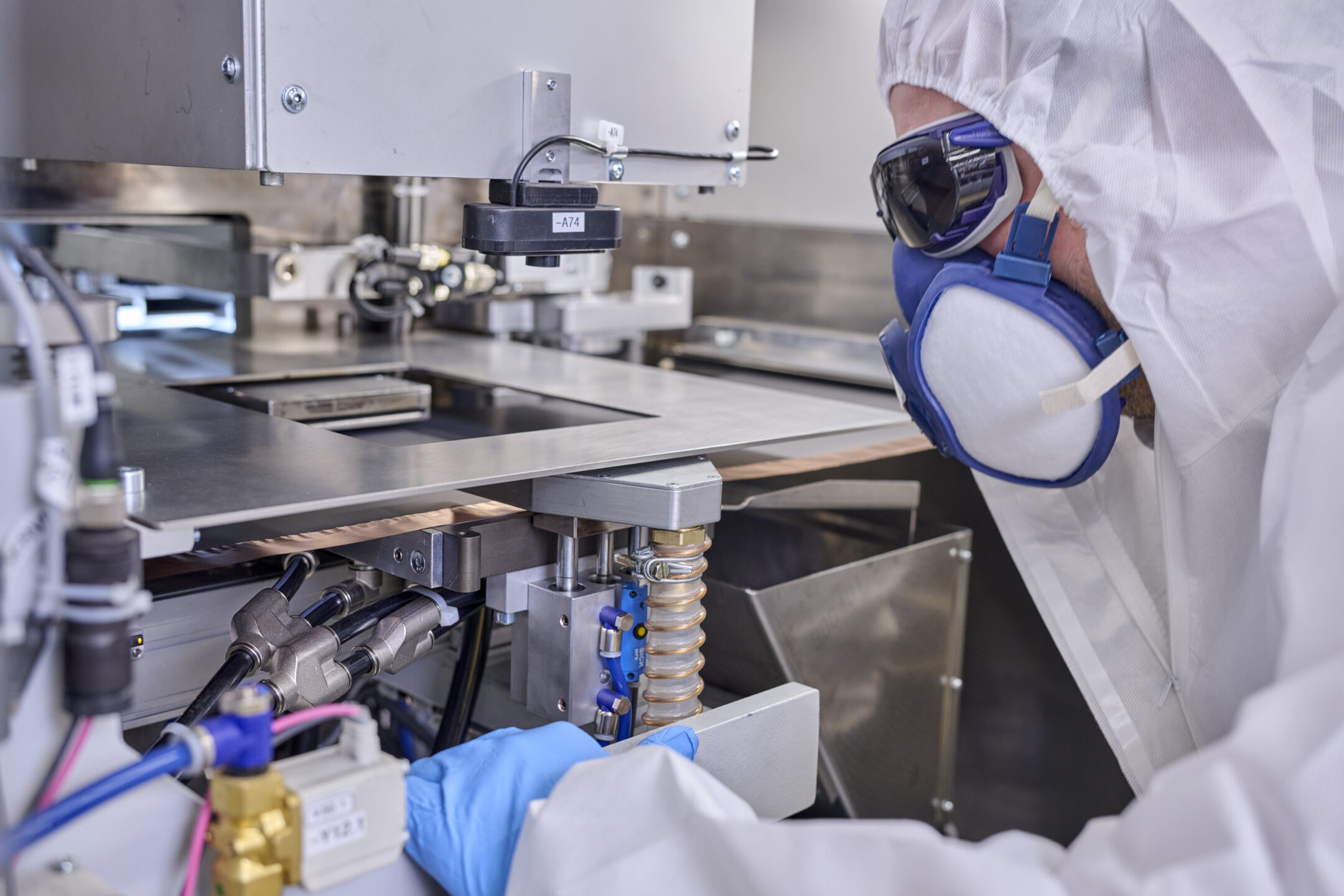 Person in Schutzausrüstung steht vor der Laserstation und schaut diese an