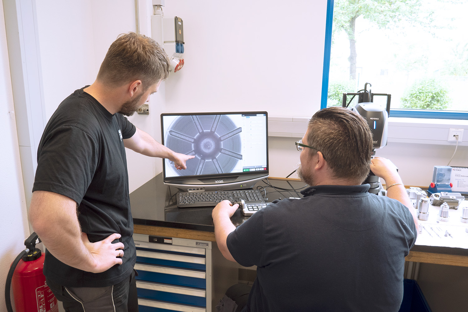 Zwei Sonplas Mitarbeiter untersuchen etwas unter einem Mikroskop